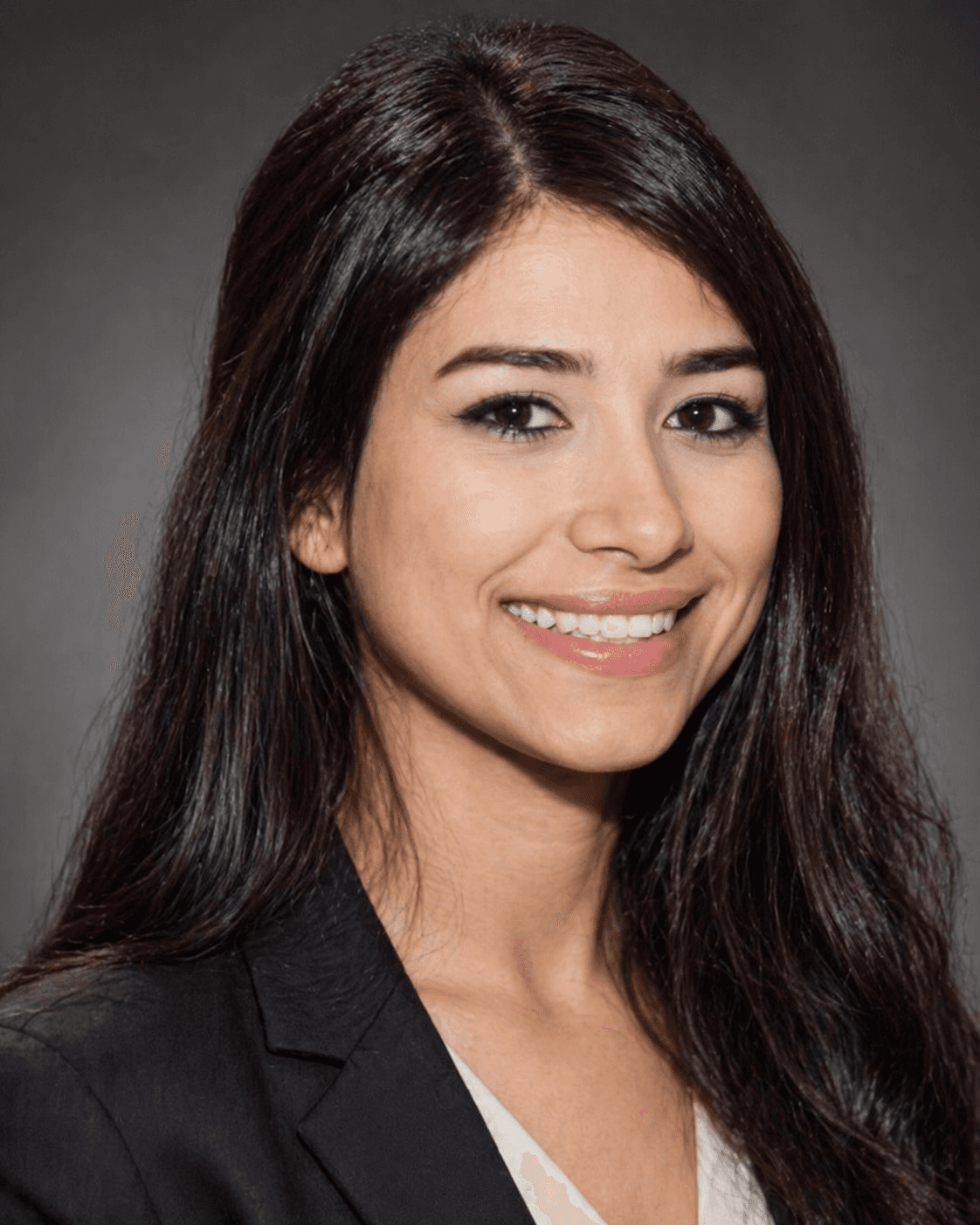 Professional headshot of a smiling woman with long dark hair wearing a black blazer.